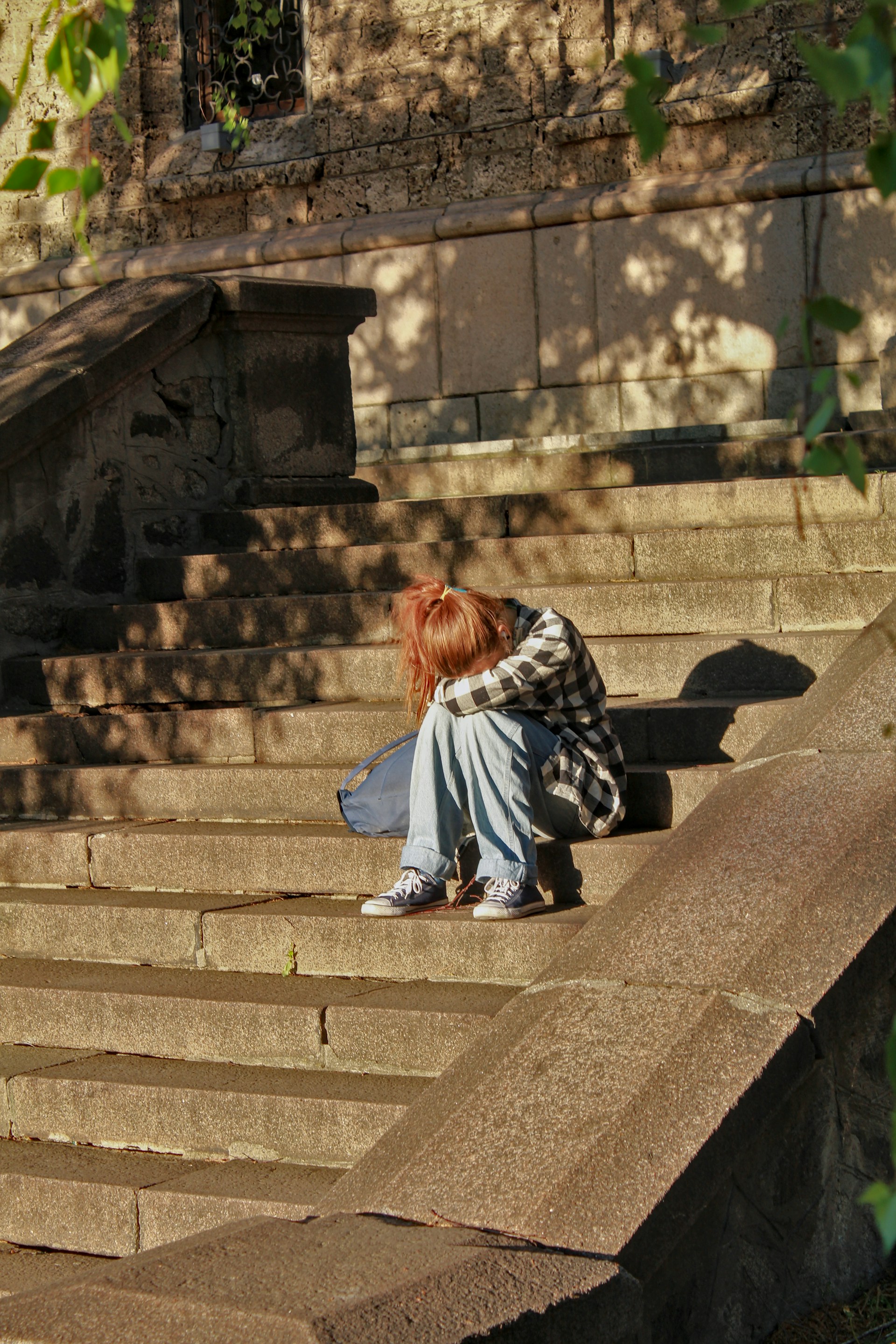 Counselling girl head down sat on steps sad lonely